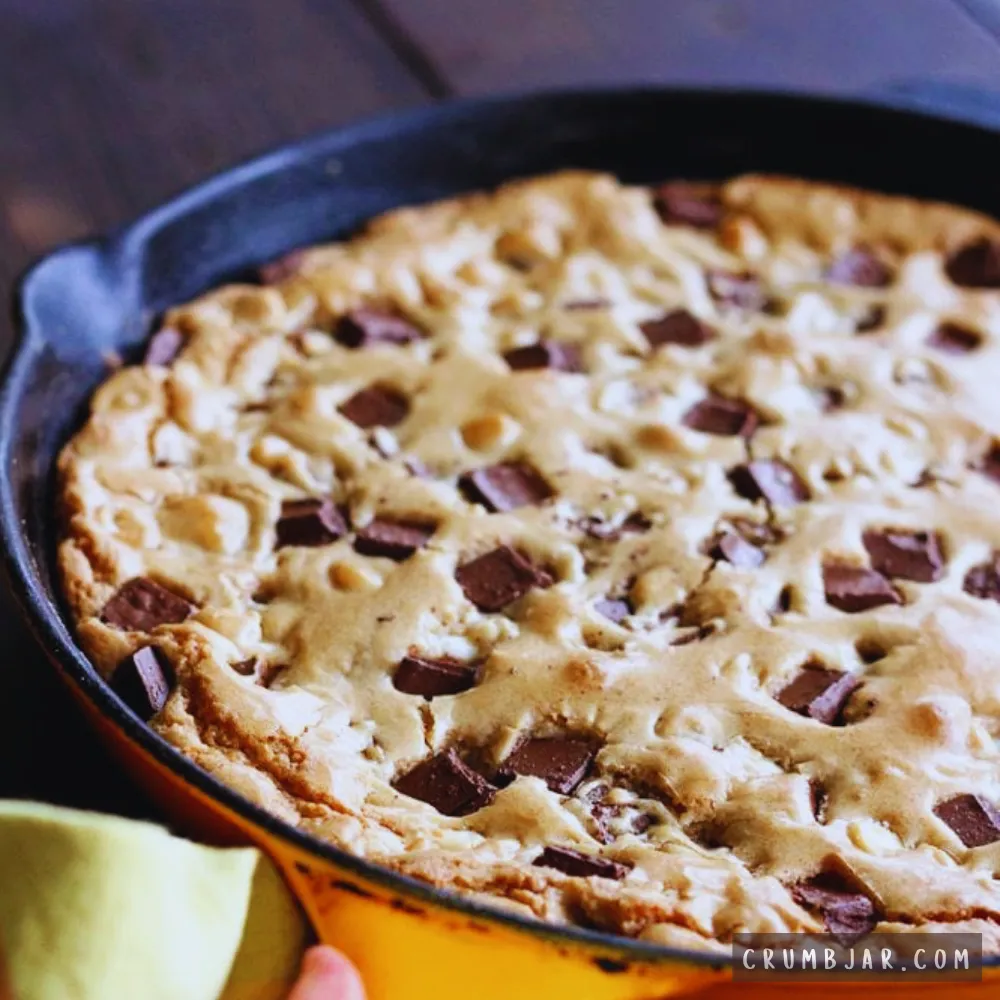 Freshly baked golden 5-ingredient chocolate chip skillet cookie loaded with melted chocolate chunks, served warm in a cast-iron skillet.