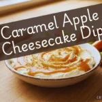 A bowl of creamy cheesecake dip drizzled with caramel sauce and graham cracker crumbs, served with fresh apple slices and graham crackers, with text overlay reading "Caramel Apple Cheesecake Dip".